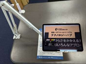 アームで固定したタブレットを拡大読書器代わりに使っている様子